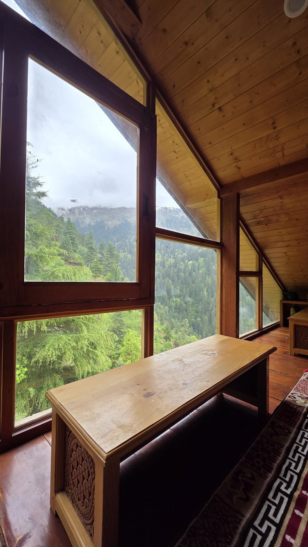 Wooden desk beside tall windows at Safar Hostel in the morning