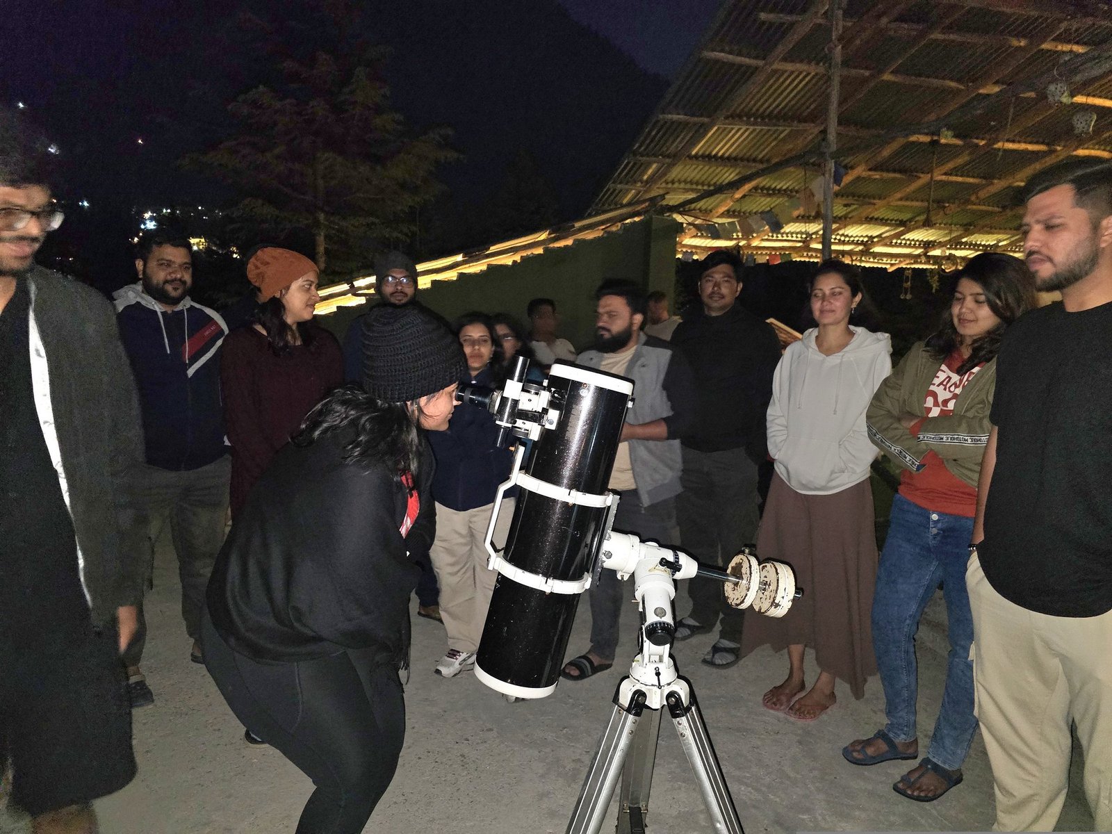 Safar guests gathered around a telescope on a clear night